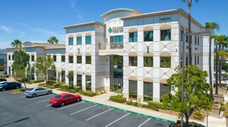 Exterior view Vein Treatment Clinic a modern medical office building under a clear blue sky.