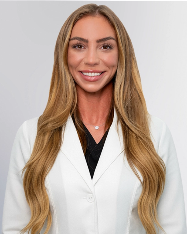 A professional portrait of a Physician Assistant at Vein Treatment Clinic. She is wearing a white medical coat and standing with her arms crossed, representing the expert and compassionate clinical team dedicated to patient care and pain relief.