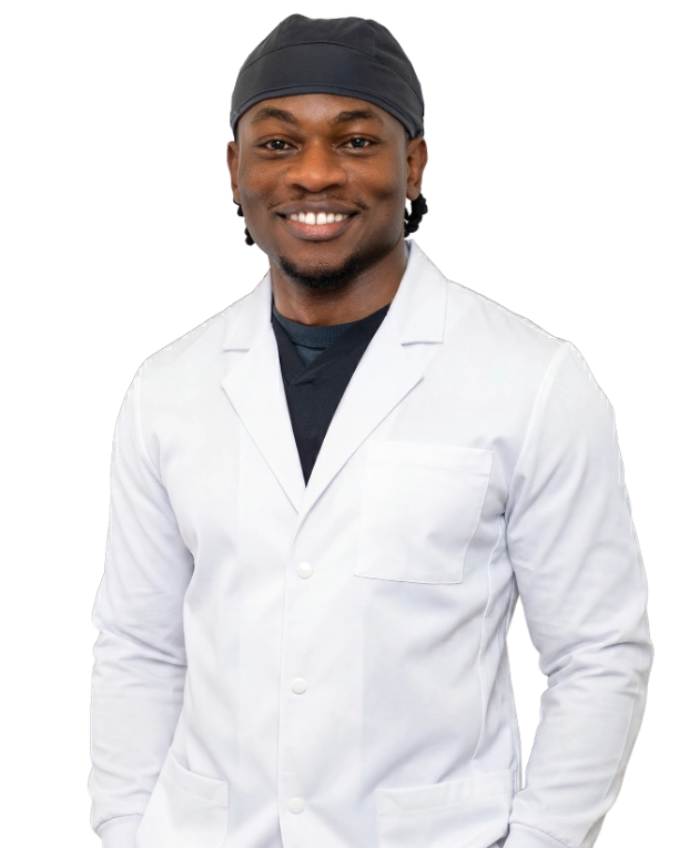 Professional headshot of Dr. Baron Ekeledo wearing a white lab coat and dark headband, smiling at the camera against a black background. This is a standard medical professional portrait used for clinic or practice identification.