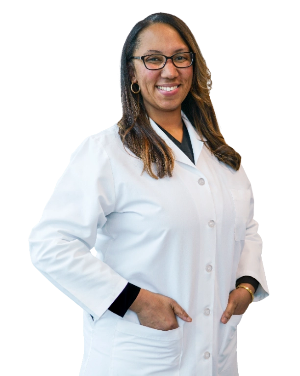 Professional headshot of Dr. Tamara Green wearing a white lab coat over dark scrubs and glasses, smiling confidently against a black background. This official clinical portrait represents a healthcare provider ready for patient consultations and medical practice.