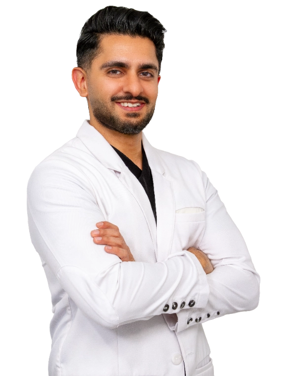 Professional headshot of Dr. Akash Mehta posed with arms crossed against a black background, wearing a white blazer and black shirt. This formal studio portrait is suitable for medical practice marketing and professional representation.