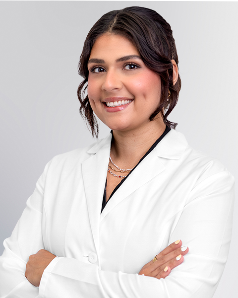 Professional headshot of the Advanced Practice Provider Sahar Hormozdiaran wearing a white lab coat, smiling at the camera against a grey background. This is a standard medical professional portrait used for clinic or practice identification.