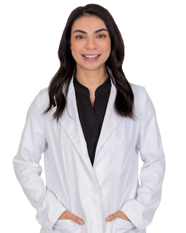 Professional headshot of the Advanced Practice Provider Dominique Lekander wearing a white lab coat, smiling at the camera against a grey background. This is a standard medical professional portrait used for clinic or practice identification.
